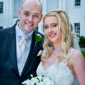 Portrait of the smiling newlyweds at the front of the White House at their Beaumont Estate summer wedding