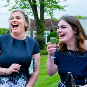 Candid wedding photography of two ladies laughing away during the summer drinks reception at this Beaumont Estate wedding
