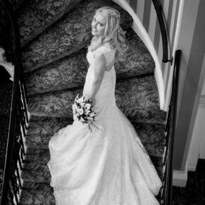 Photography of the bride on the staircase captured from above with her gown perfectly positioned on the staircase at her Beaumont Estate wedding