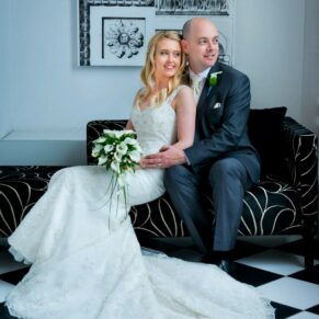 Photography of the newlyweds sat on a sofa by the window in the White House at their Beaumont Estate wedding