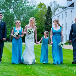 Photography of the bridal party taking a relaxed stroll in the lush gardens at their Beaumont Estate summer wedding