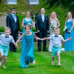 Kids running with the wedding bridal party watching them during their garden dash at the Beaumont Estate
