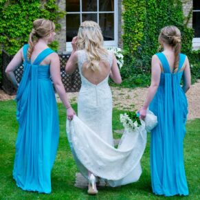 Photography of the bride strolling with her bridesmaids through the gardens of the Beaumont Estate towards the main building on her wedding day