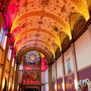 Interior photography of the historic Beaumont Estate chapel captured in all its glory with up-lighters at this Old Windsor wedding celebration