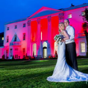 Newlyweds photography against the floodlit White House captured at dusk on their glorious summer's day wedding at The Beaumont Estate in Windsor