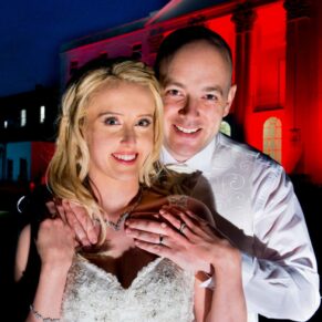 Atmospheric dusk photography of the newlyweds at the front of the historic Windsor wedding venue The Beaumont Estate