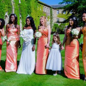 The very colourful bridal party walking in the gardens of the hotel under perfect blue skies