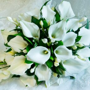 The bride's stunning white lily bouquet placed delicately onto her dress before the ceremony at her Beaumont Estate wedding venue