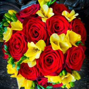 The bride's vibrant bouquet placed on a dark contrasting oak bench