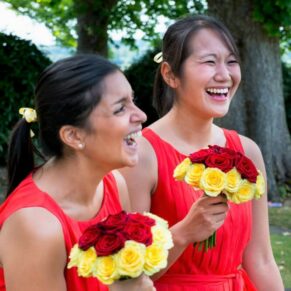 Two giggling bridesmaids captured during the lively drinks reception in Bisham Abbey's gorgeous grounds