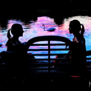 The bridesmaids sat on a bench during the evening's dramatic sunset at Bisham Abbey
