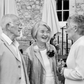 Black and white reportage capture of some of the friends during the drinks reception at the abbey
