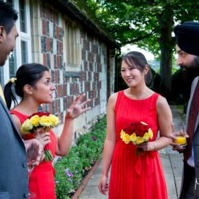 Reportage photography of some of the guests enjoying the after ceremony banter in the grounds of Bisham Abbey