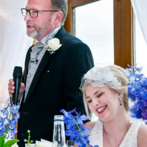 Dad's speech in progress with his giggling daughter next to him