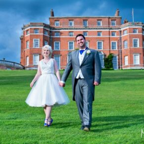 Photography of the bride & groom taking a stroll on their glorious sunny wedding day at Brocket Hall with the main house ion the background