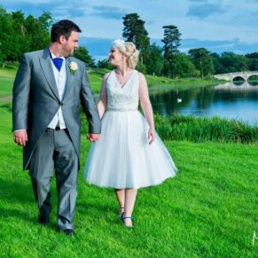 The smiling newlyweds taking a lakeside stroll hand in hand on this glorious sunny day