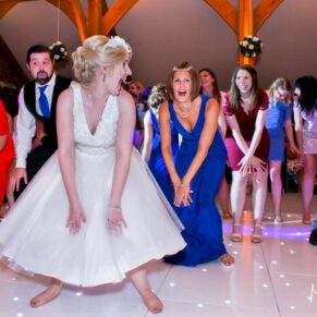 Photography of guests who have joined the bride on the dancefloor for some energetic moves at her Brocket Hall wedding