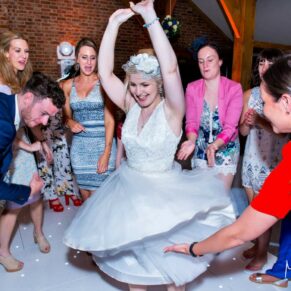 The bride loving her moment being centre stage on the dancefloor at her wedding reception in the barn at Brocket Hall