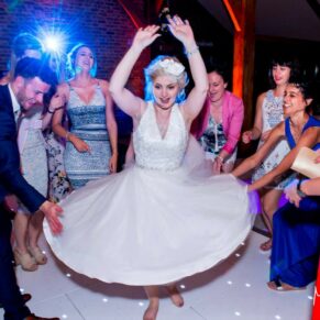 Photography of the bride getting the partying into full swing with her energetic moves at her Brocket Hall wedding in Hertfordshire