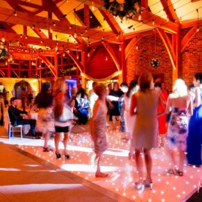 Atmospheric photography captured of the wedding guests on the dancefloor in the barn at Brocket Hall in Hertfordshire