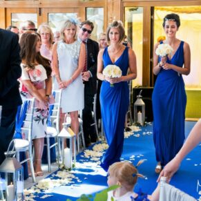 The smiling bridesmaids entering the ceremony in the barn