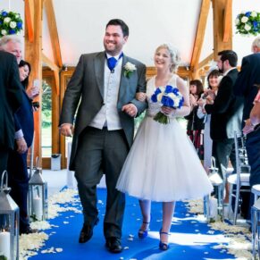 The smiling newlyweds exiting their barn ceremony on the estate