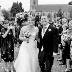 The newlyweds walking through the outdoor reception aisle at their riverside wedding