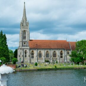 View over the River Thames towards All Saints Church on a dark sky day - captured from the hotel gardens