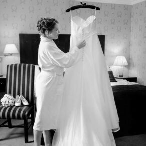 Photography of the bride adjusting her gown prior to her wedding ceremony at the Compleat Angler Hotel in Marlow