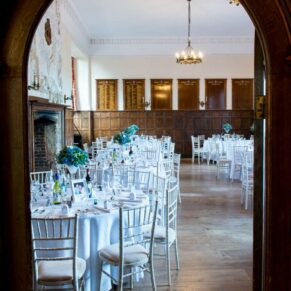 Setup for the wedding breakfast captured through an archway into the dining room at this Dorton House wedding