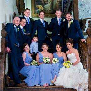 The bridal party captured in a casual pose on the grand staircase at Dorton House in Buckinghamshire