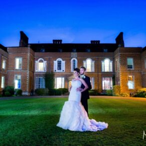 The newlyweds captured at dusk with some additional floodlighting to create the wow factor for this pose at their Dorton House wedding