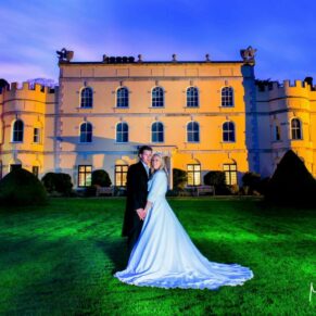 The bride and groom captured at dusk in the main gardens with striking floodlighting used to create the absolute wow factor