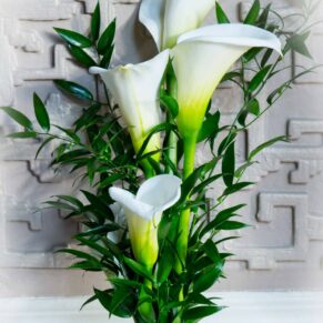 Delicate white flowers placed against a highly detailed feature wall in the Dining Room