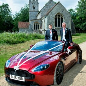 The groom and best man in the convertible car outside the church before the ceremony