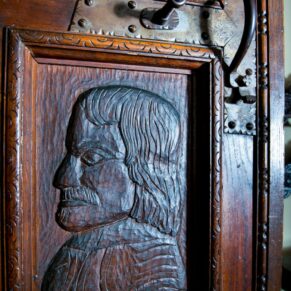 Hand carved oak panels into the Great Hall lit with dramatic window lighting