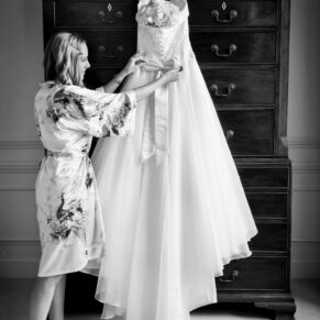 The bride adjusting her gown pre ceremony beside a feature window in the Bridal Suite