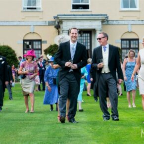 Guests walking across the lawn to where the formal group poses will be taken