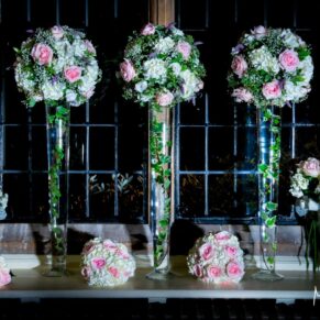 A tall floral display in the bar area window lit with atmospheric lighting