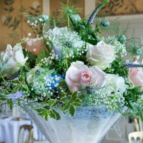 A delicate floral arrangement on the raised glass table centre in the Dining Room