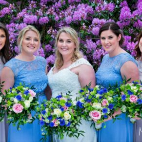 The ladies pose for the camera beside the vibrant May rhododendrons