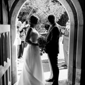 Silhouette shot of the newlyweds as the exit the church on the estate