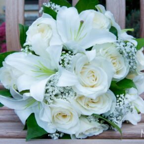 The bride's delicate white bouquet placed on a stripy chair
