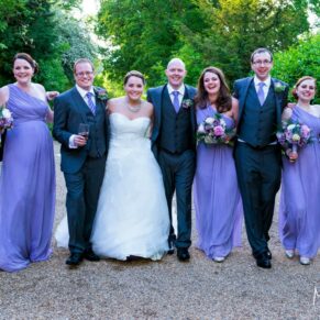The smiling bridal party take a relaxed stroll in the stunning grounds