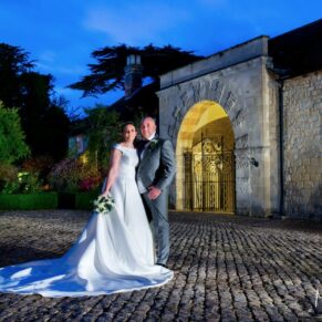 Atmospheric night shot of the bride and groom outside The Hartwell Court buildings at Hartwell House