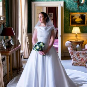 The bride looking out of the window with the grand Hartwell House interiors in the background