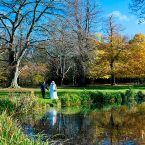 Autumn colours for the newlyweds as they take a stroll by the lake in the gardens of Hartwell House