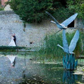The newlyweds stroll beside the lake at their Le Manoir Aux Quat Saisons summer wedding