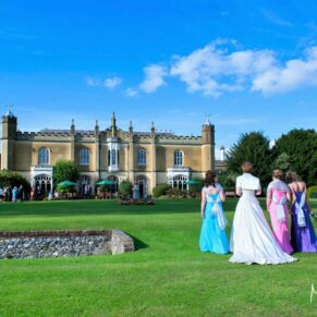 The bride takes a stroll towards the abbey with her bridesmaids under a perfect blue sky