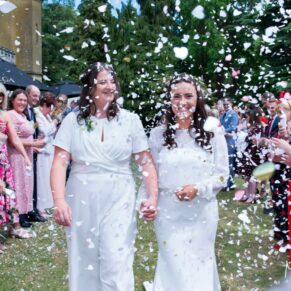 Same sex Buckinghamshire wedding photography of the newlyweds in the confetti aisle at Missenden Abbey